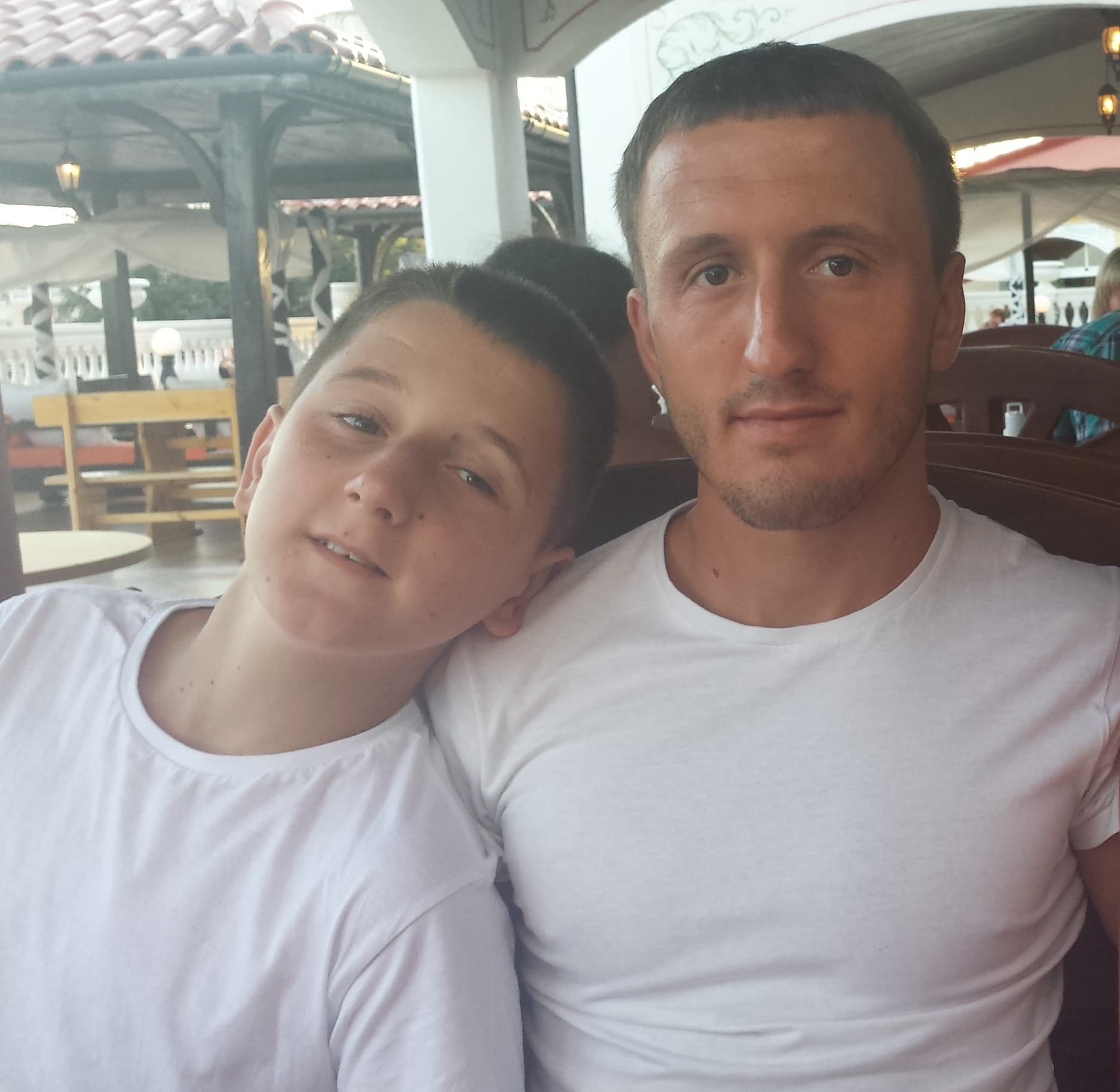 Leon Kercova and his brother Shemsi Kercova sitting together in white T-shirts.